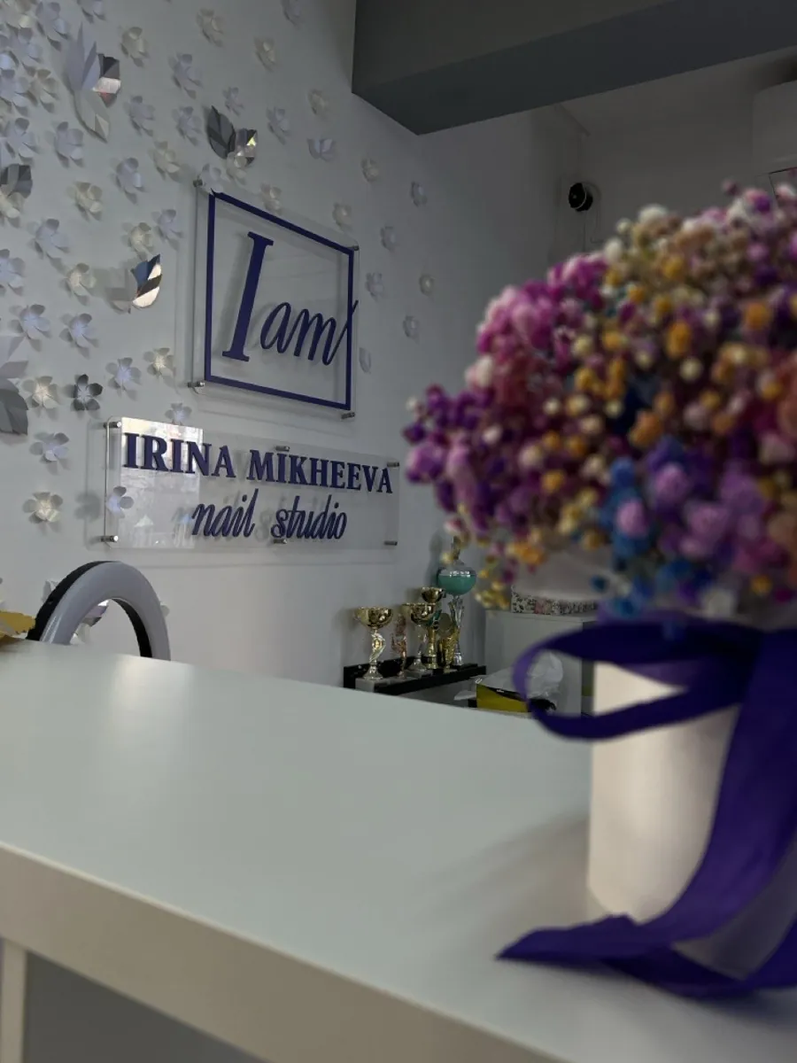 Интерьер студии IRINA MIKHEEVA nail studio: ресепшен, кубки и логотип